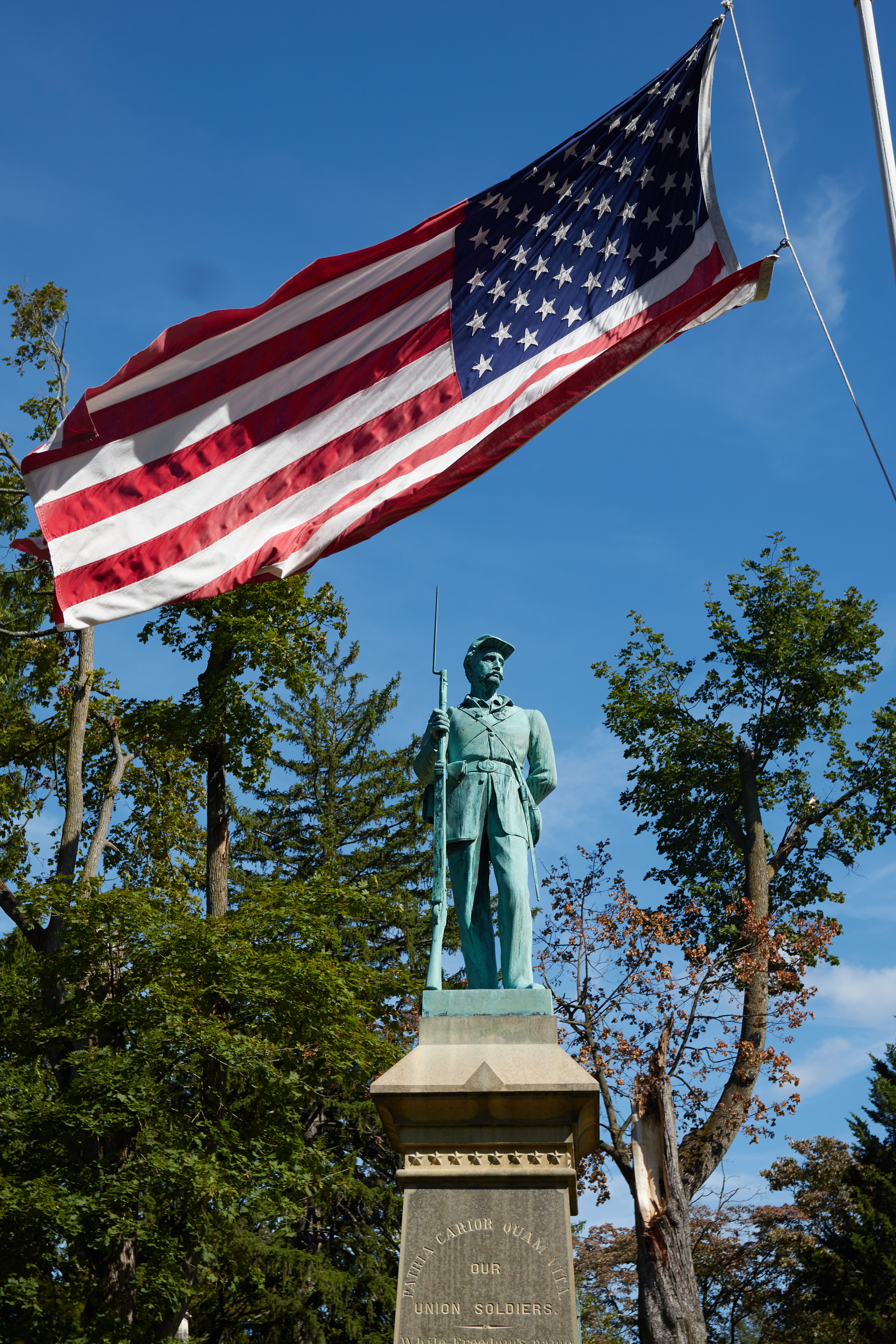 Civil war Monument, with American flag flying above sculpture of soldier.