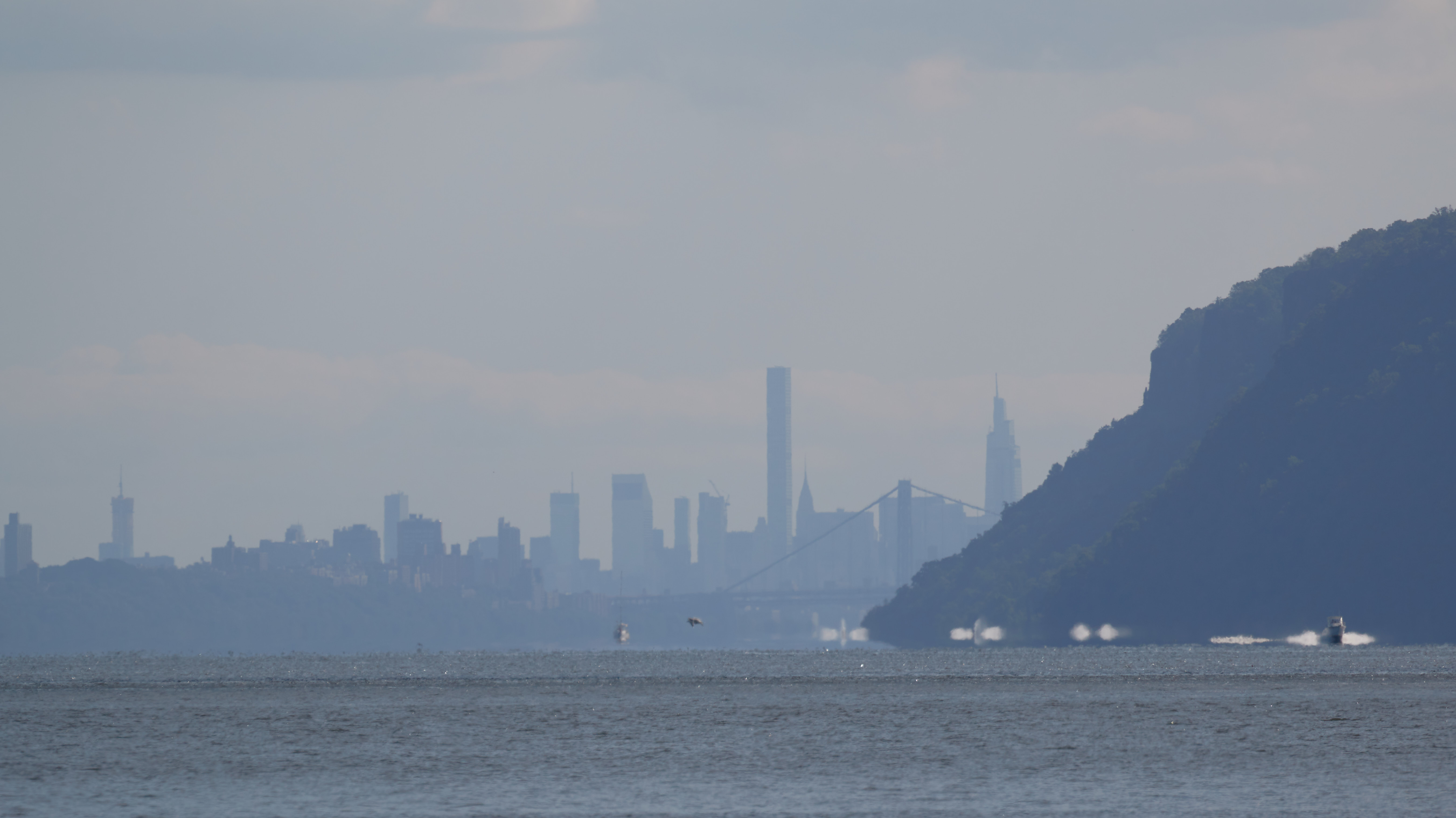 View of bluffs along Hudson River, with Manhattan skyline in background.