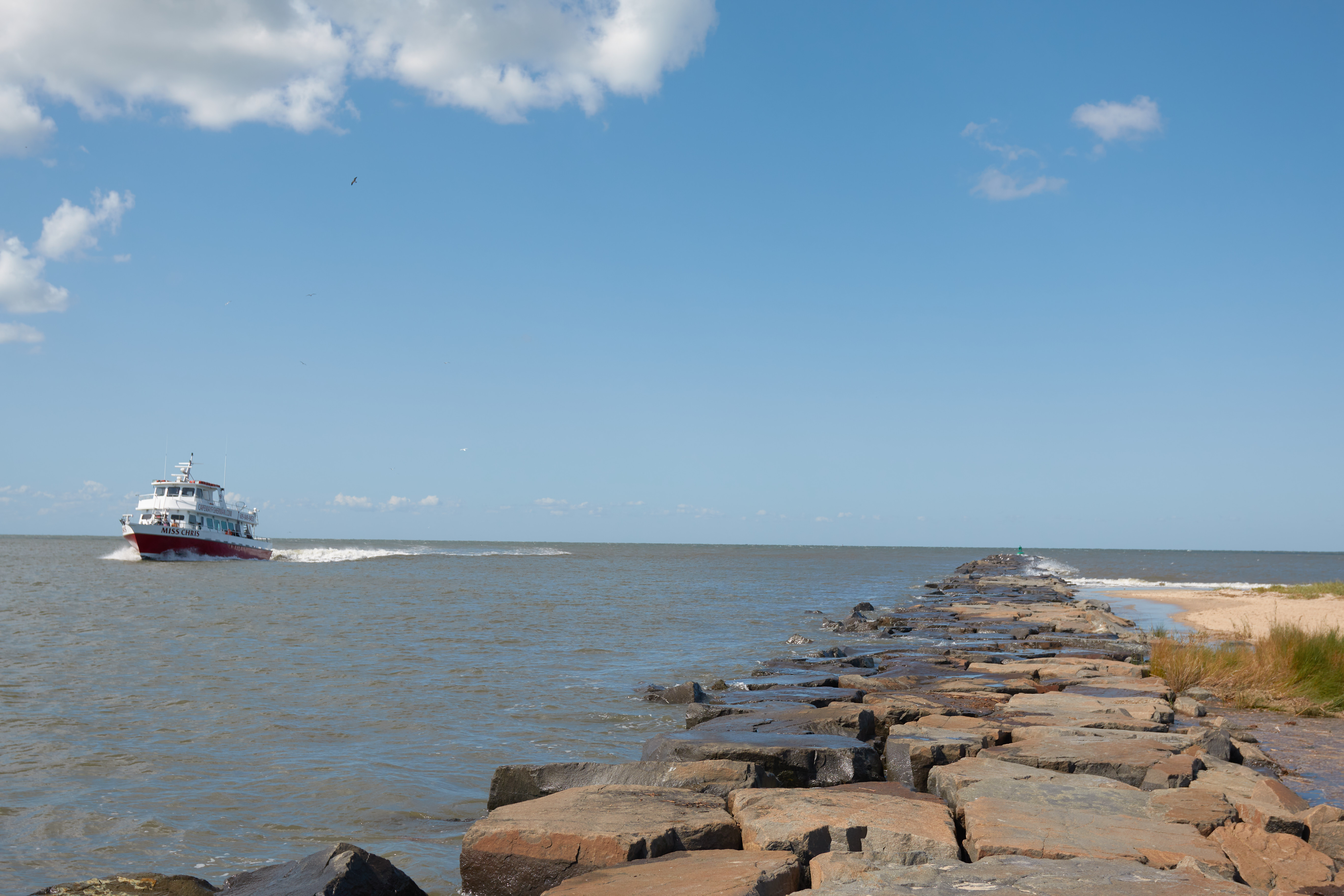 Ship passing stone breakwater in Delaware Bay.