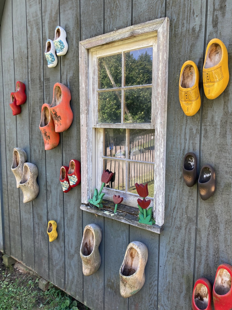 Clogs nailed to side of shed in cemetery.