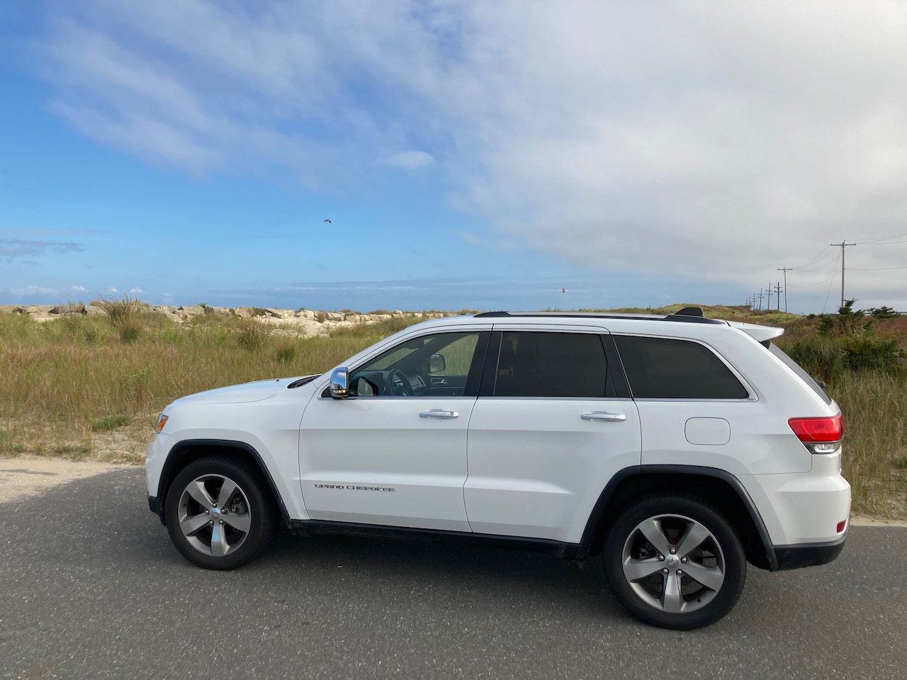 2014 Jeep Grand Cherokee parked by dunes.