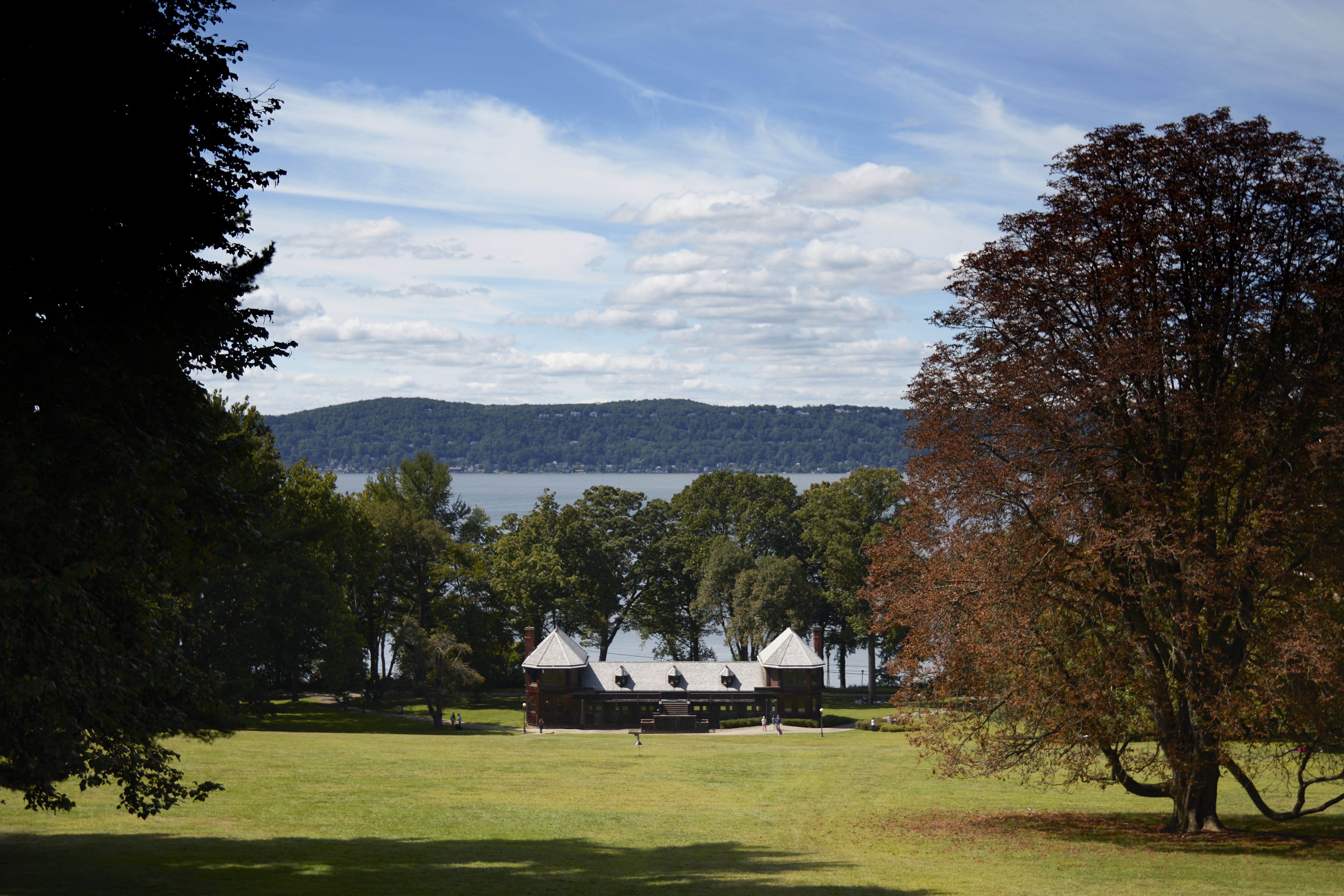 View of bowling alley down sloping grass hill, with Hudson River in background.