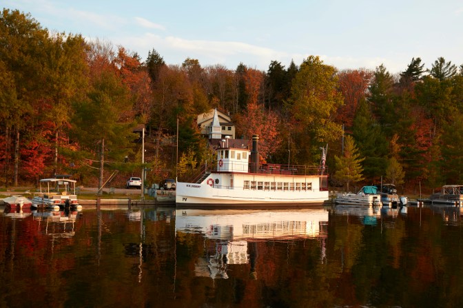 WW Durant cruise ship docked along tree-lined shore of Raquette Lake.