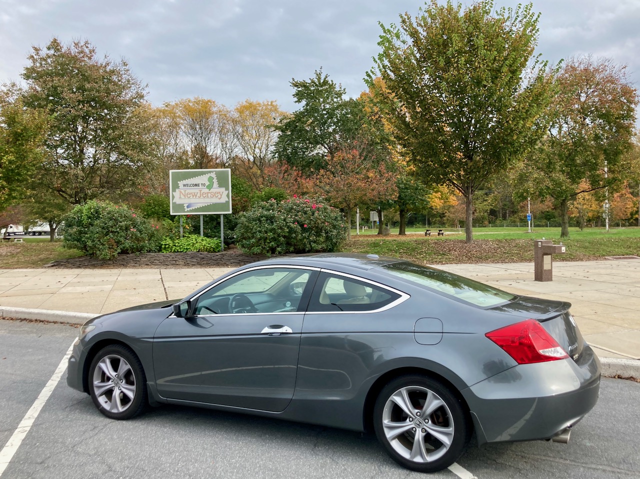 2012 Honda Accord parked beside WELCOME TO NEW JERSEY sign.