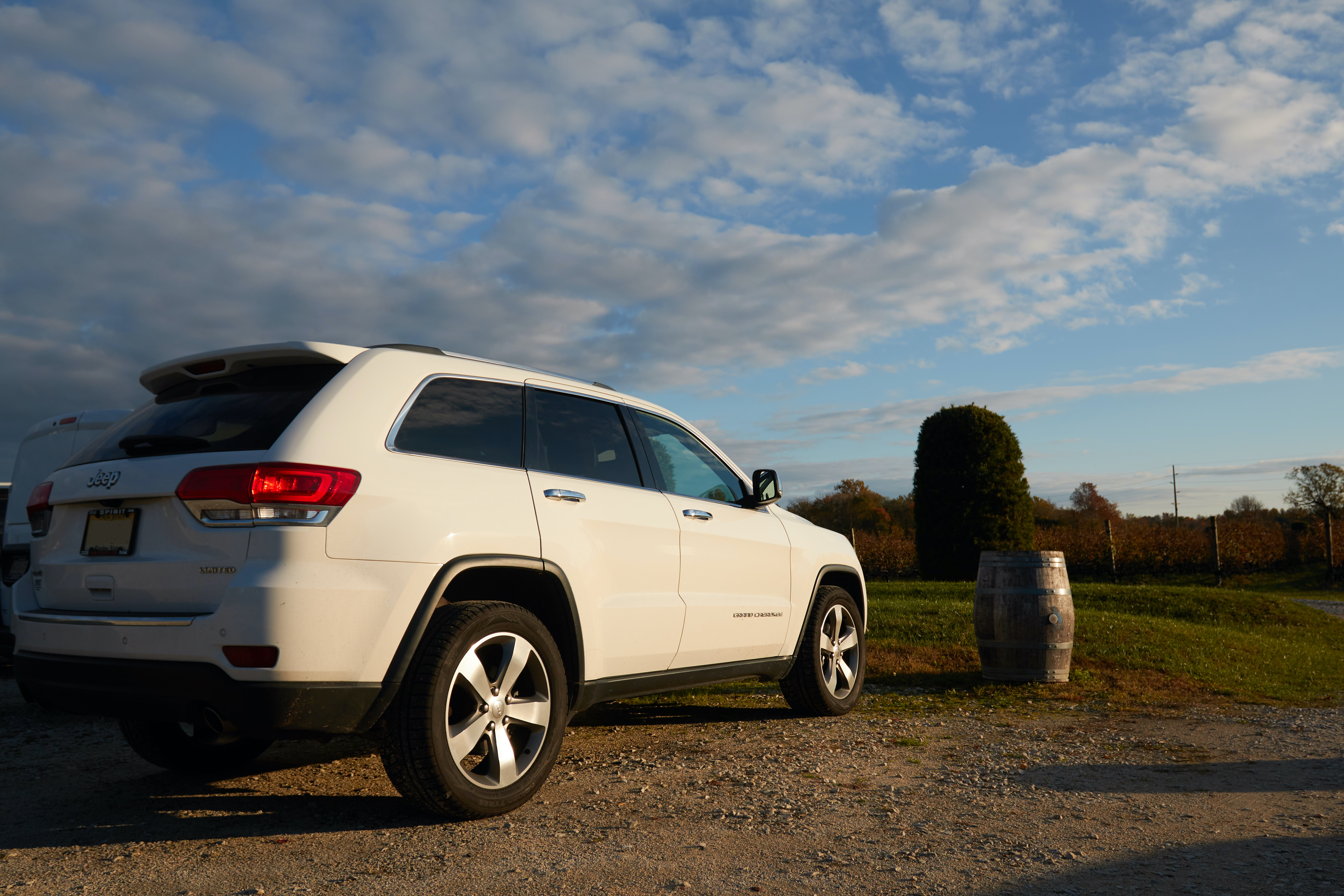 2014 White Jeep Grand Cherokee parked in vineyard.
