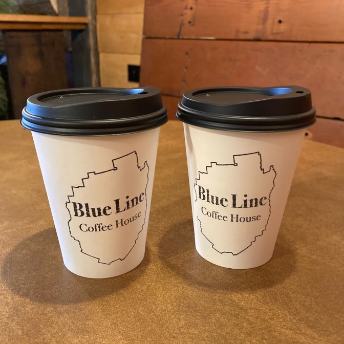 Two coffee cups on wooden table.
