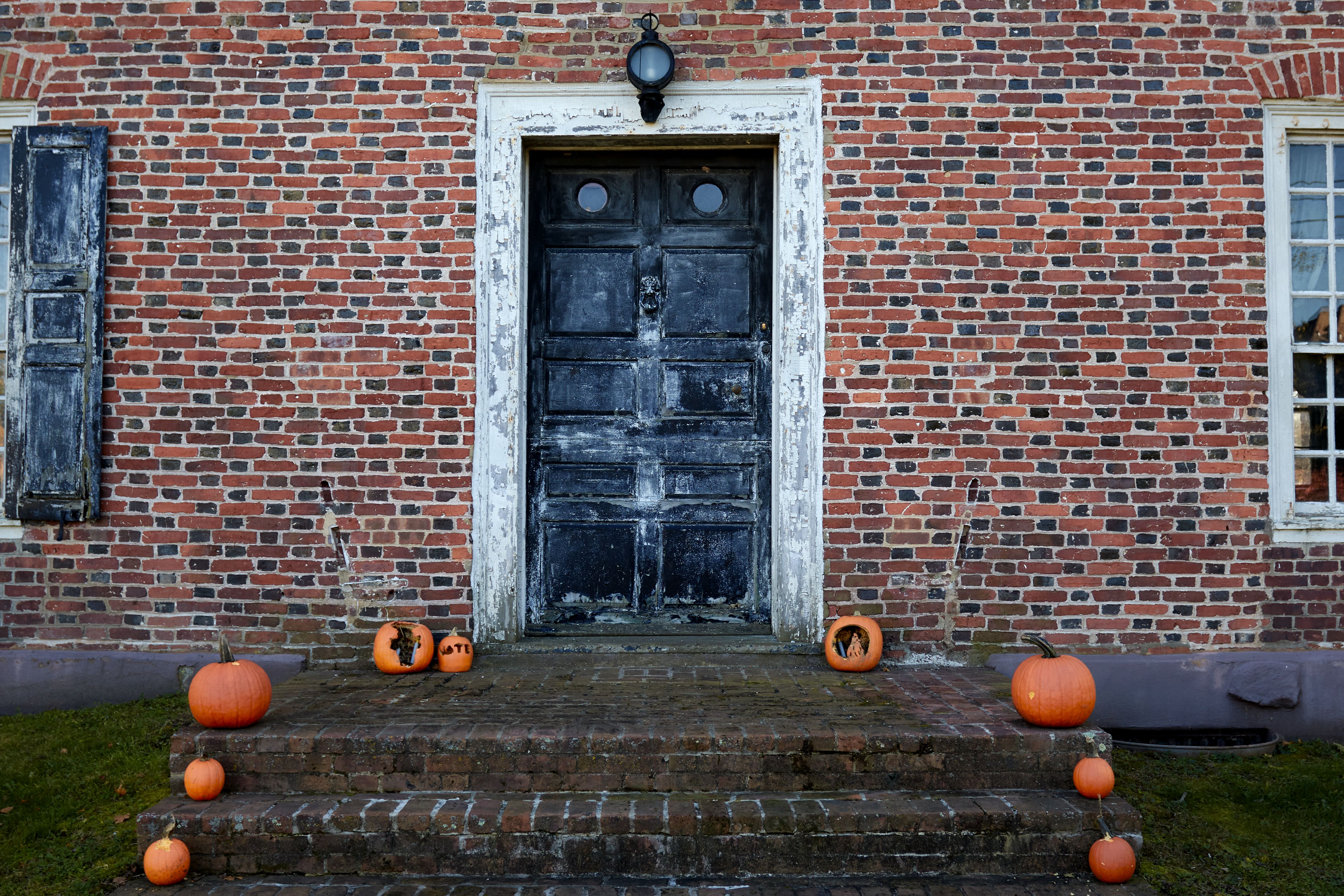 Entrance to Old Dutch Parsonage, with jack o'lanterns along sides of front steps.
