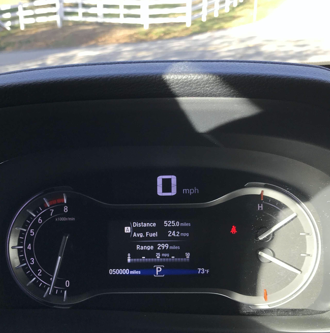 Car instrument cluster with dashboard reading 50000 miles.