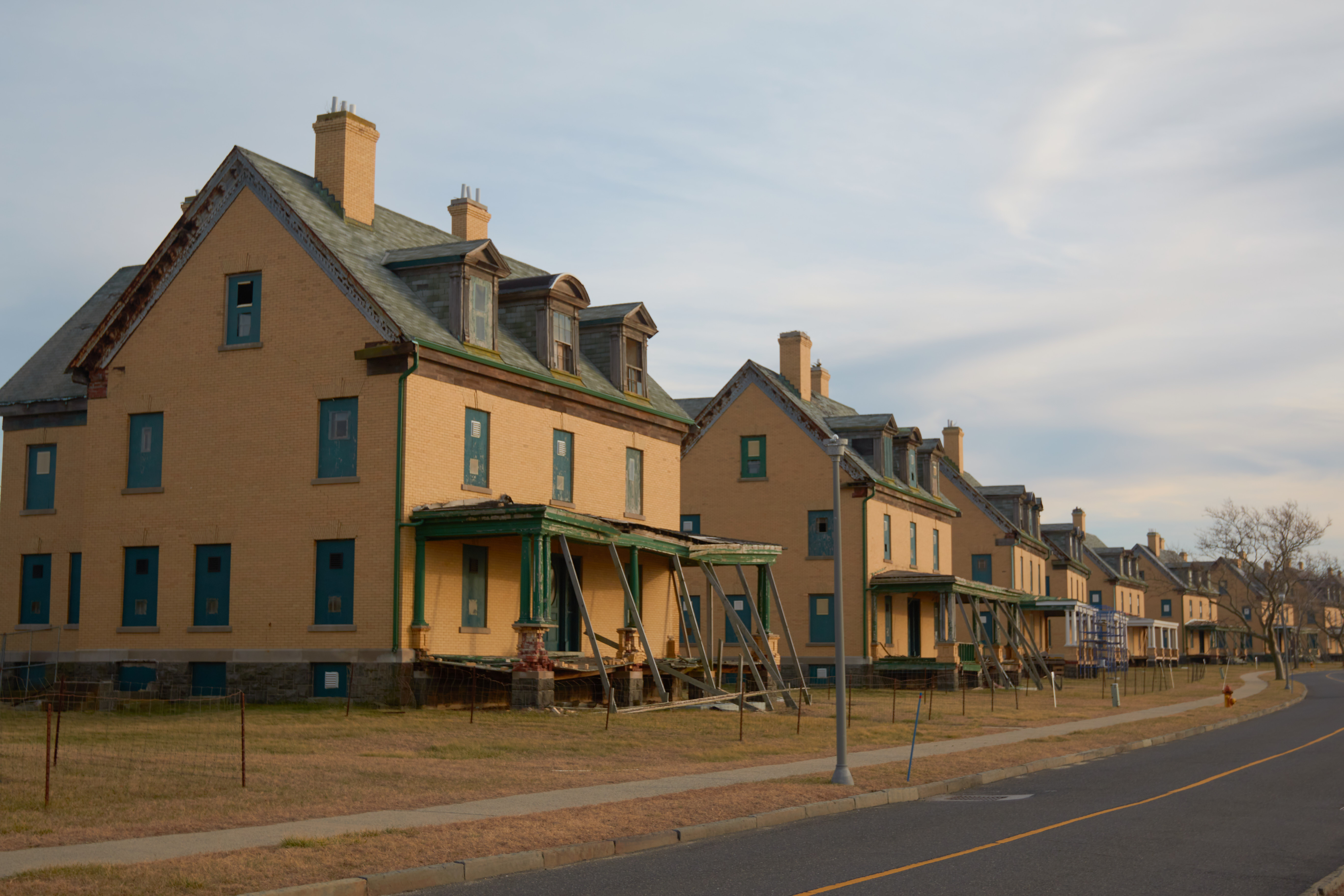 Rows of houses along road, in various states of decay.