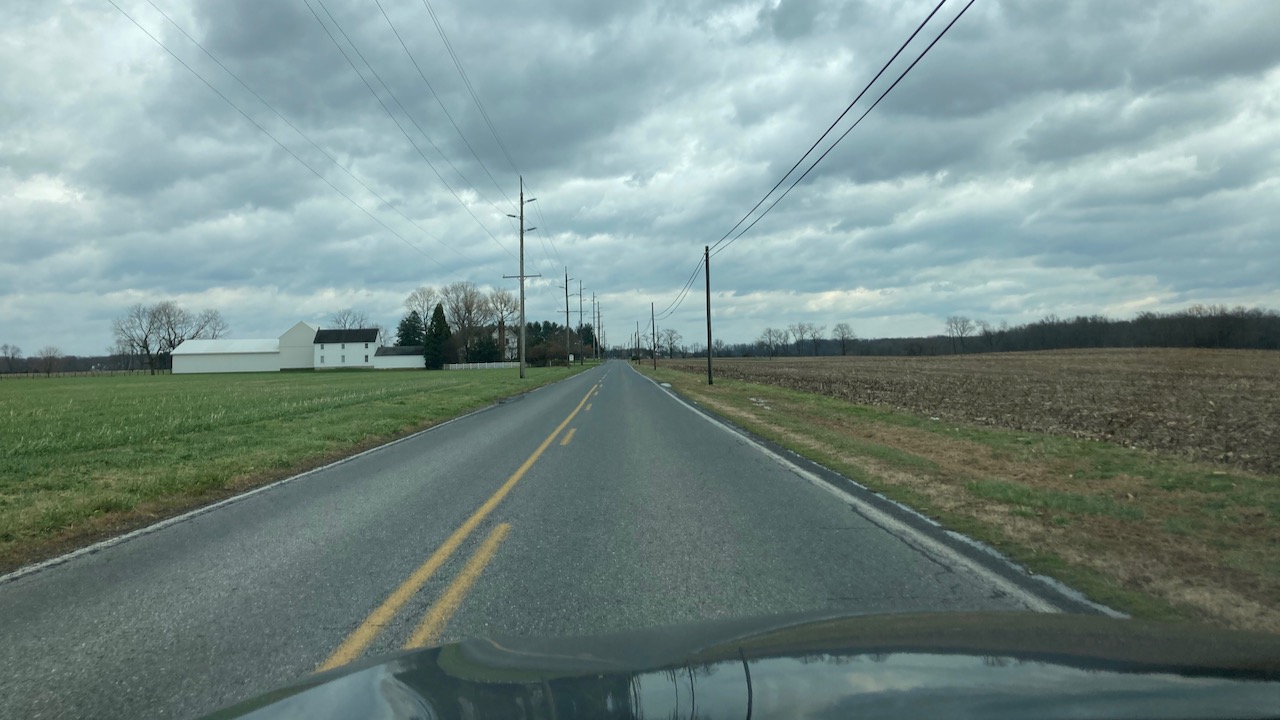 View of two-lane county road through farmland.