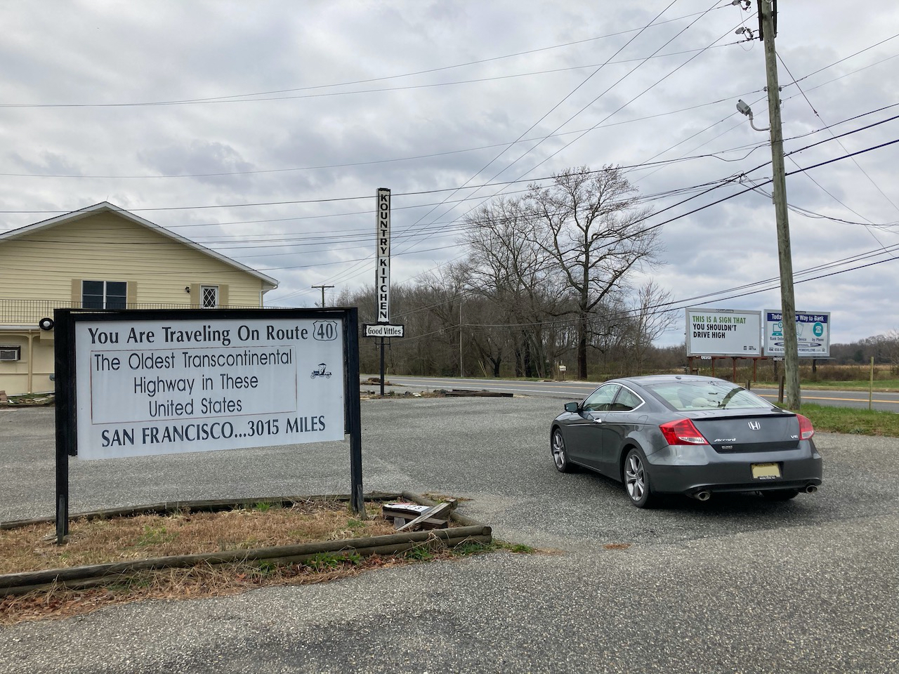 2012 Honda Accord coupe, gray, in front of sign that reads YOU ARE TRAVELING ON ROUTE 40 THE OLDEST TRANSCONTINENTAL HIGHWAY IN THESE UNITED STATES SAN FRANCISCO 3015 MILES.