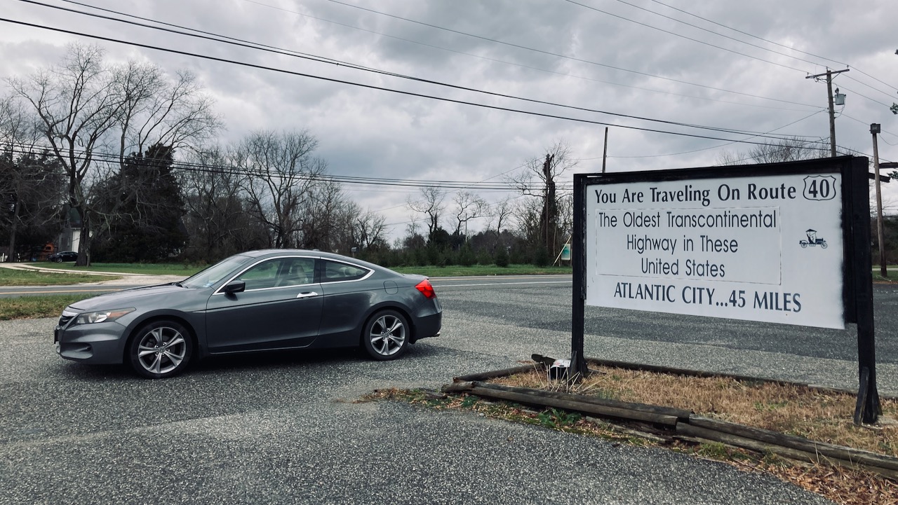 2012 Honda Accord parked next to sign that says YOU ARE TRAVELING ON ROUTE 40 THE OLDEST TRANSCONTINENTAL HIGHWAY IN THESE UNITED STATES ATLANTIC CITY 45 MILES.