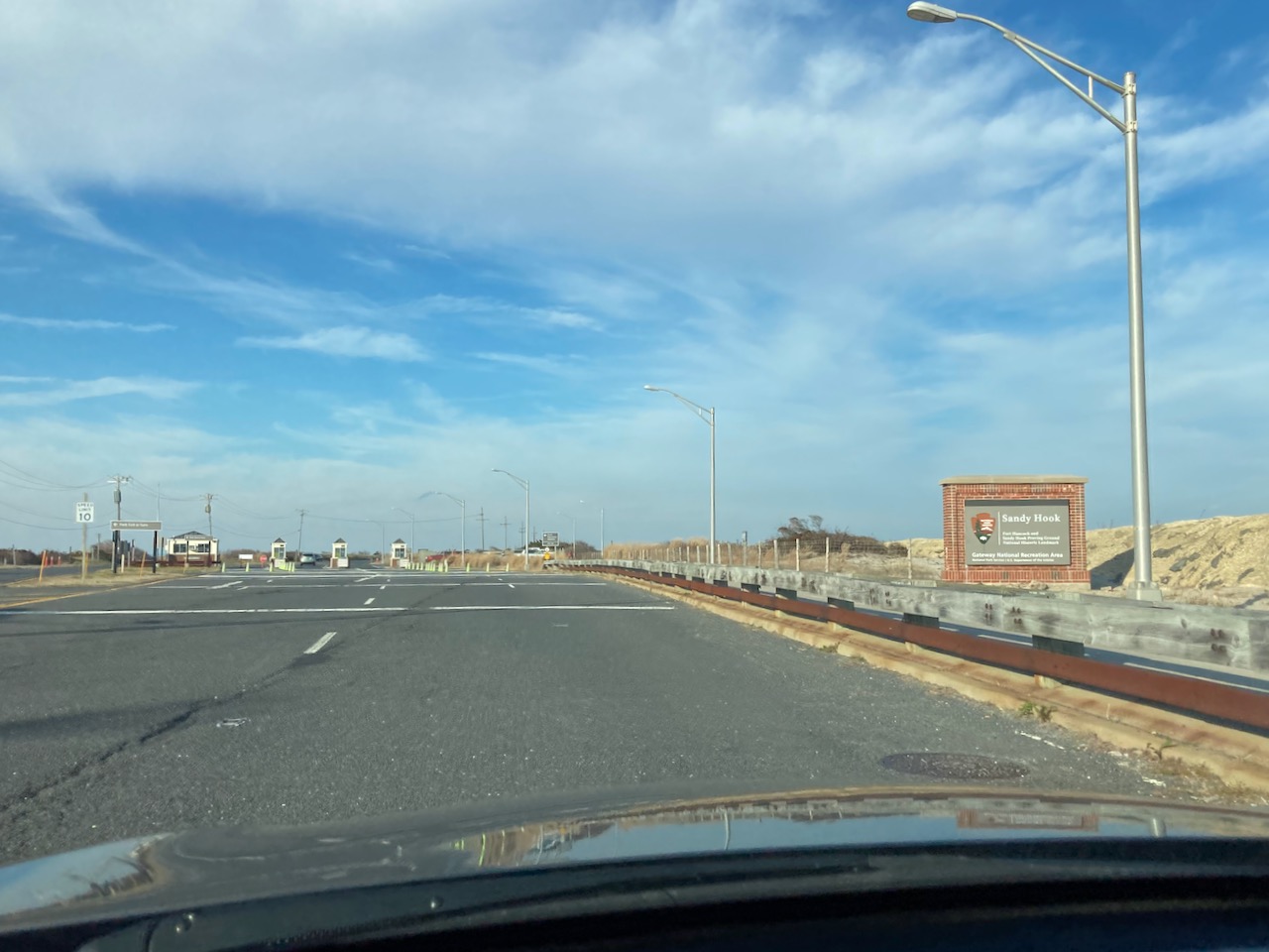 Entrance to park, with sign by road that says SANDY HOOK.