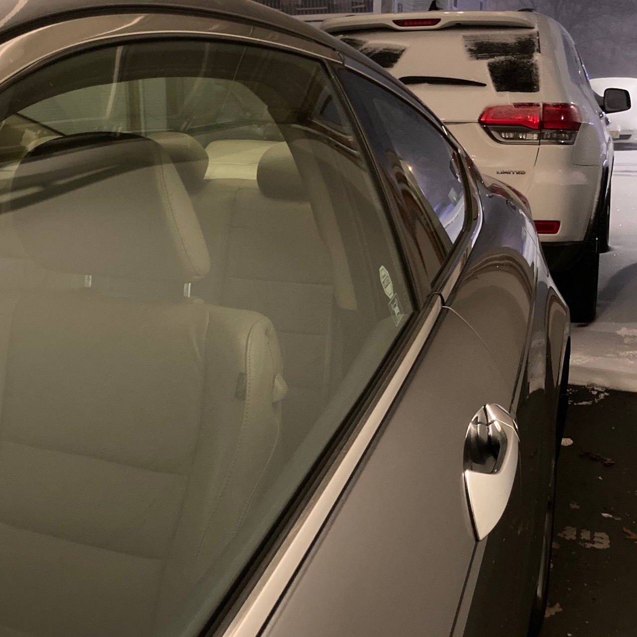 2012 Honda Accord in garage, with white Jeep Grand Cherokee in snow.