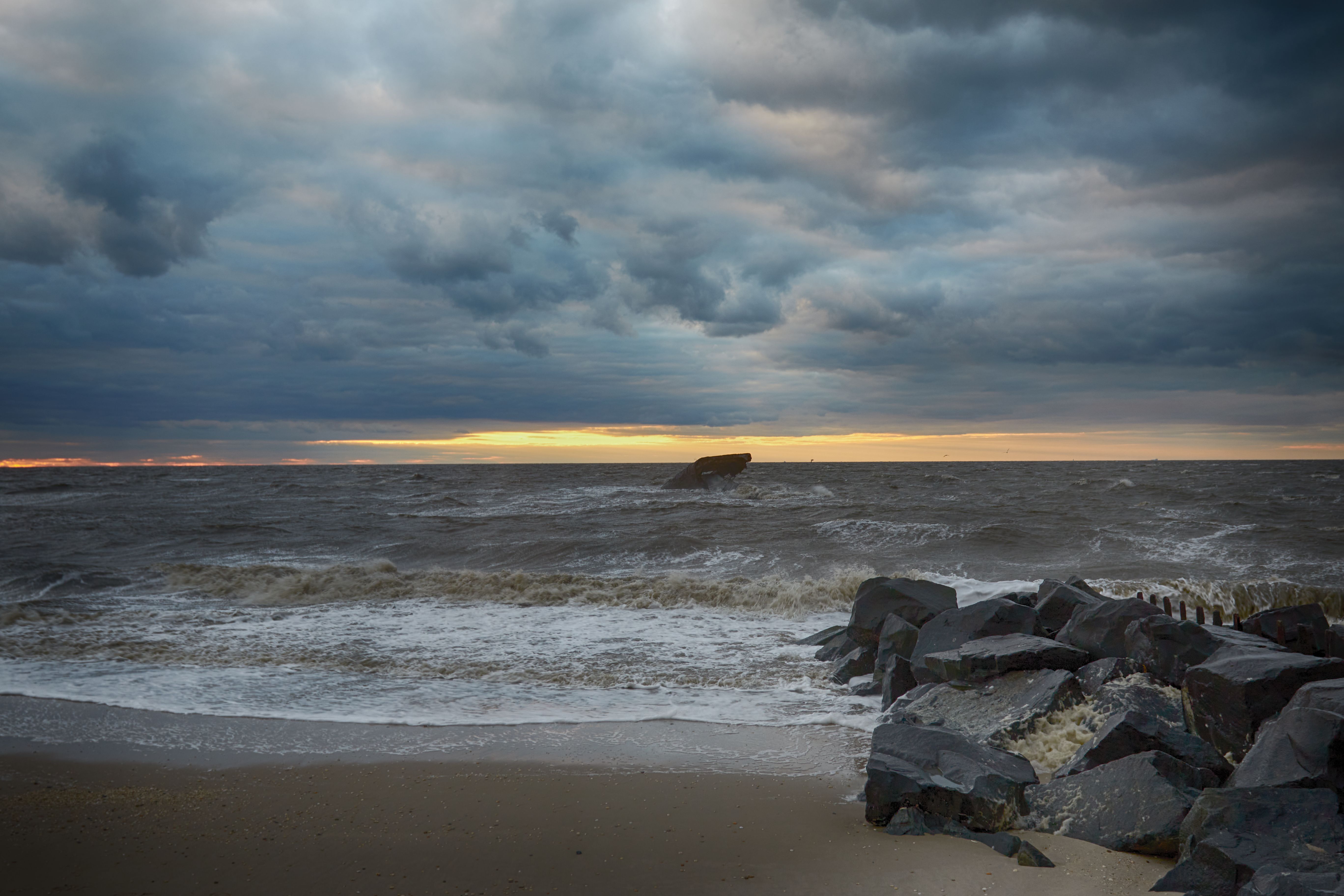 Sunset over rough waters of Delaware Bay. The remains of the concrete ship is in the distance.