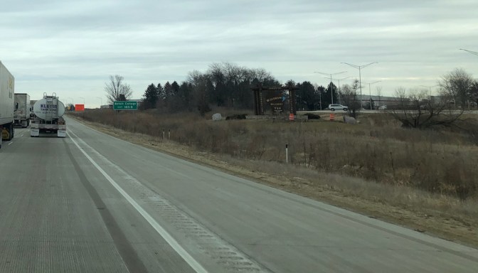 View of highway with sign for Wisconsin on the side of road.