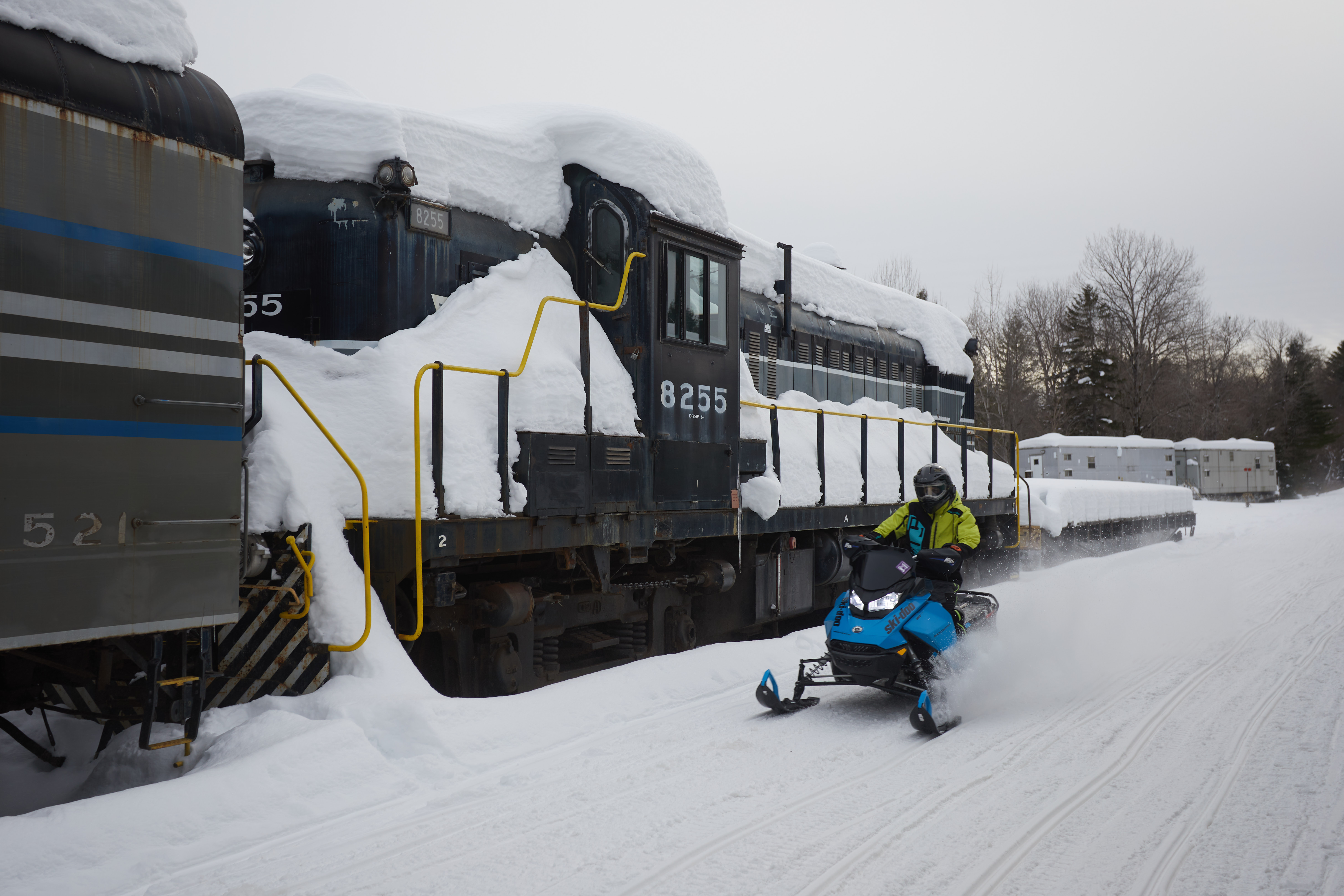 Snowmobiler speeding through train yards.