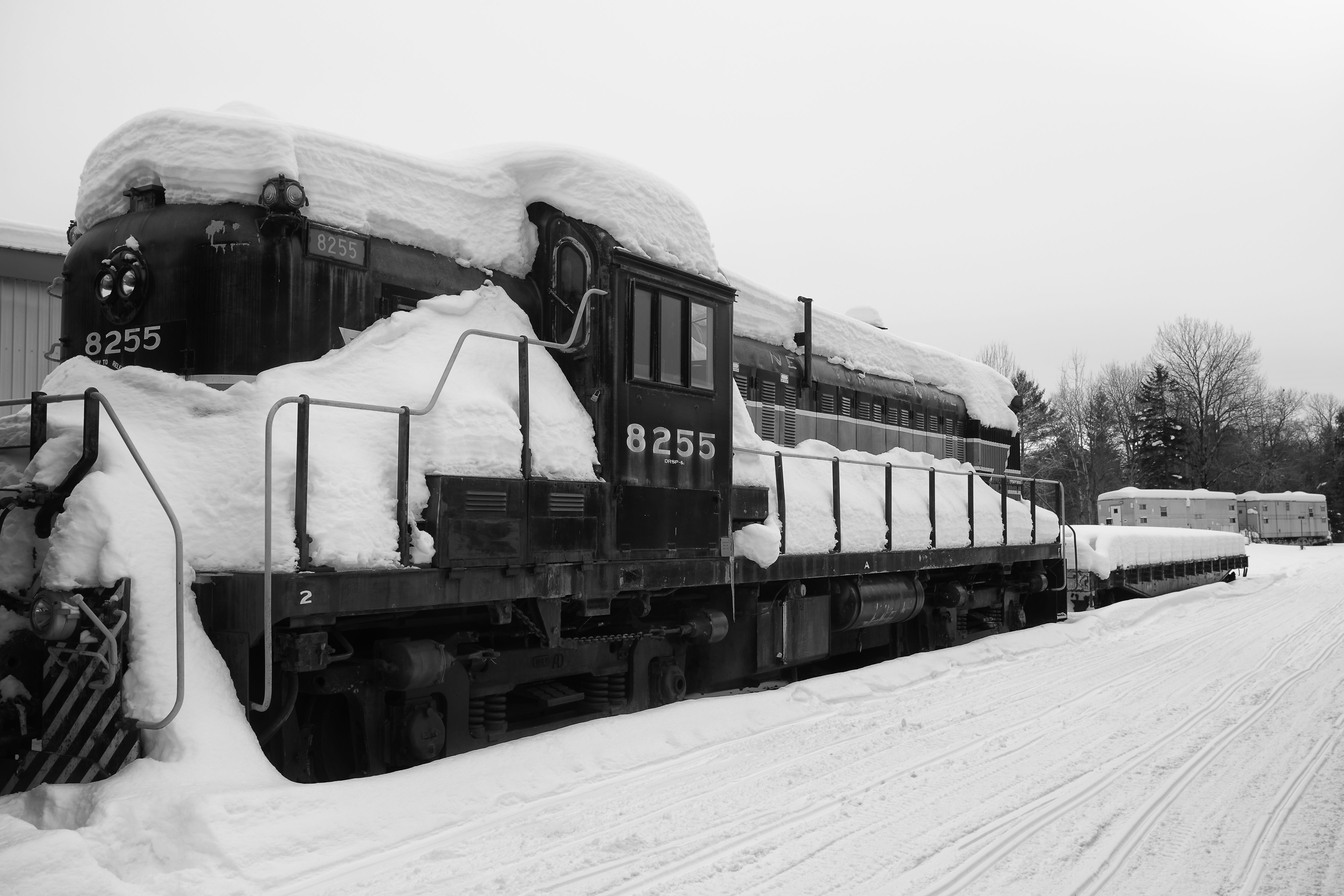 Black and white image of diesel locomotive covered in snow.