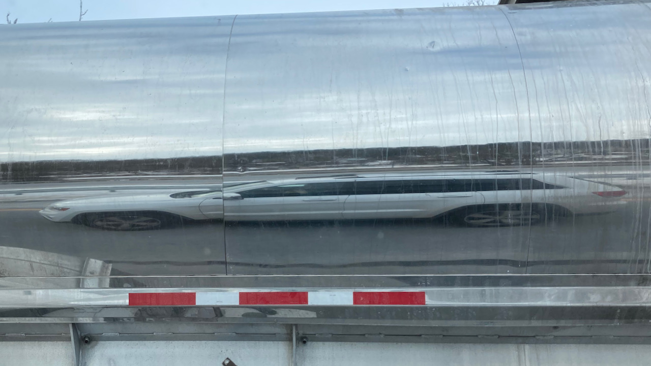 Reflection of Jeep Grand Cherokee in tanker truck.