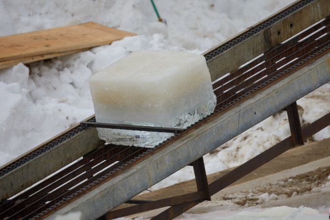 Block of ice ascending conveyor belt.