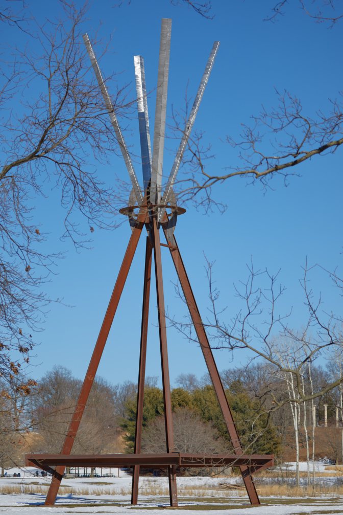 E=MC2 sculpture in field.