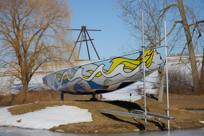 Sailboat on display, with a mermaid painted on side.
