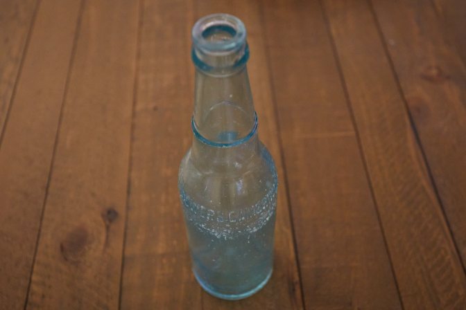 Glass bottle on wooden table.