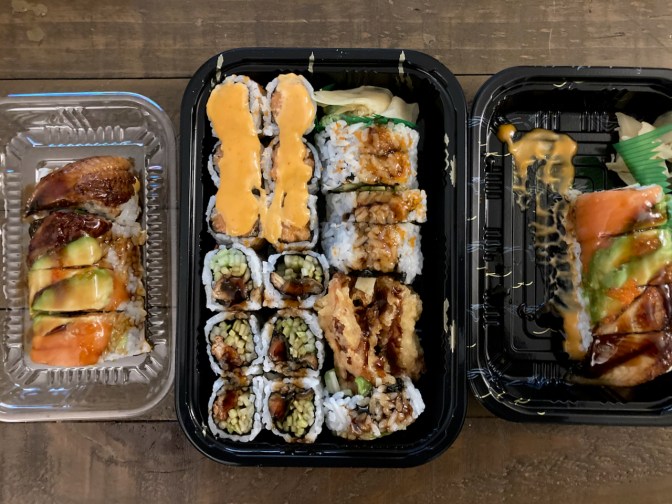 Various sushi in plastic to-go containers.