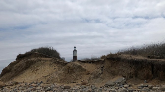 View of Lighthouse behind sand dunes.