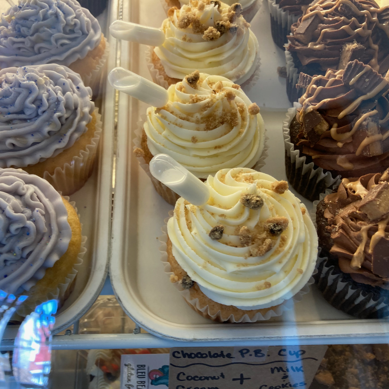 Gluten-free cupcakes under glass case.