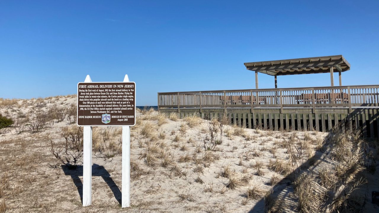 Historical marker on dune near beach.