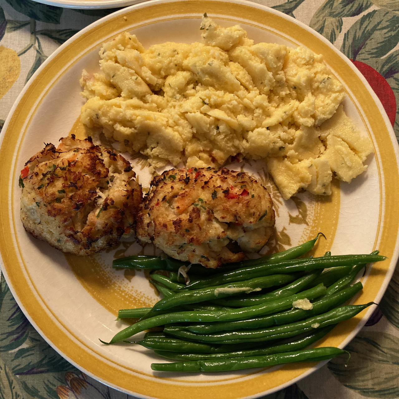 Plate with shrimp and crab cakes, string beans, and polenta.