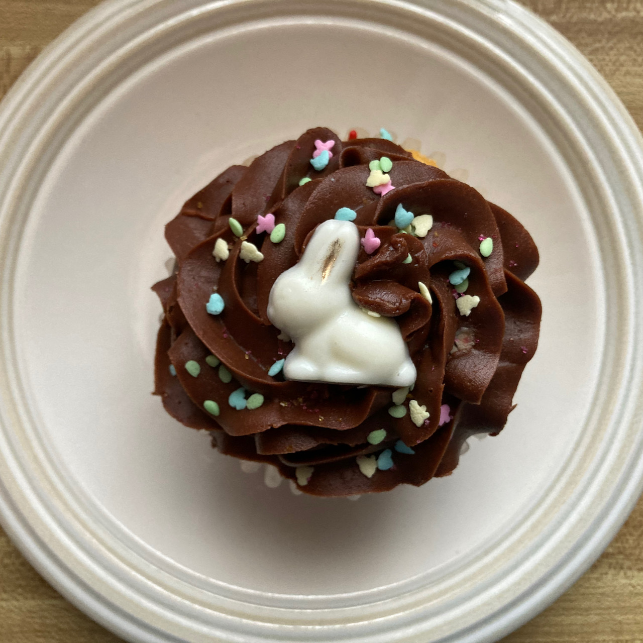 Cupcake with chocolate icing and easter bunny candy on top.
