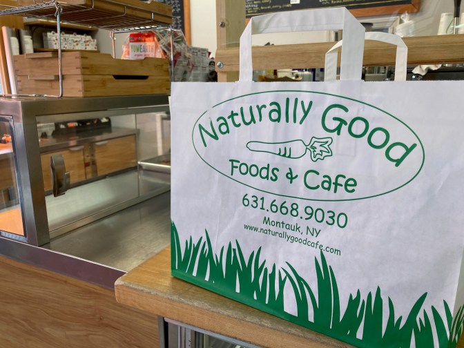 Takeout bag on counter. Bag says NATURALLY GOOD FOOD & CAFE.