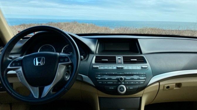 View of ocean through windshield of car.
