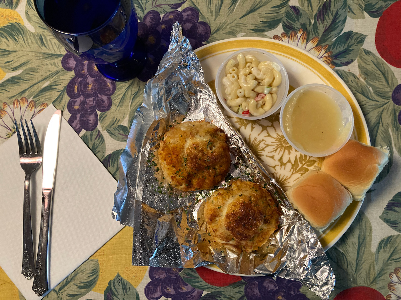 Plate with crab cakes, macaroni salad, and apple sauce.