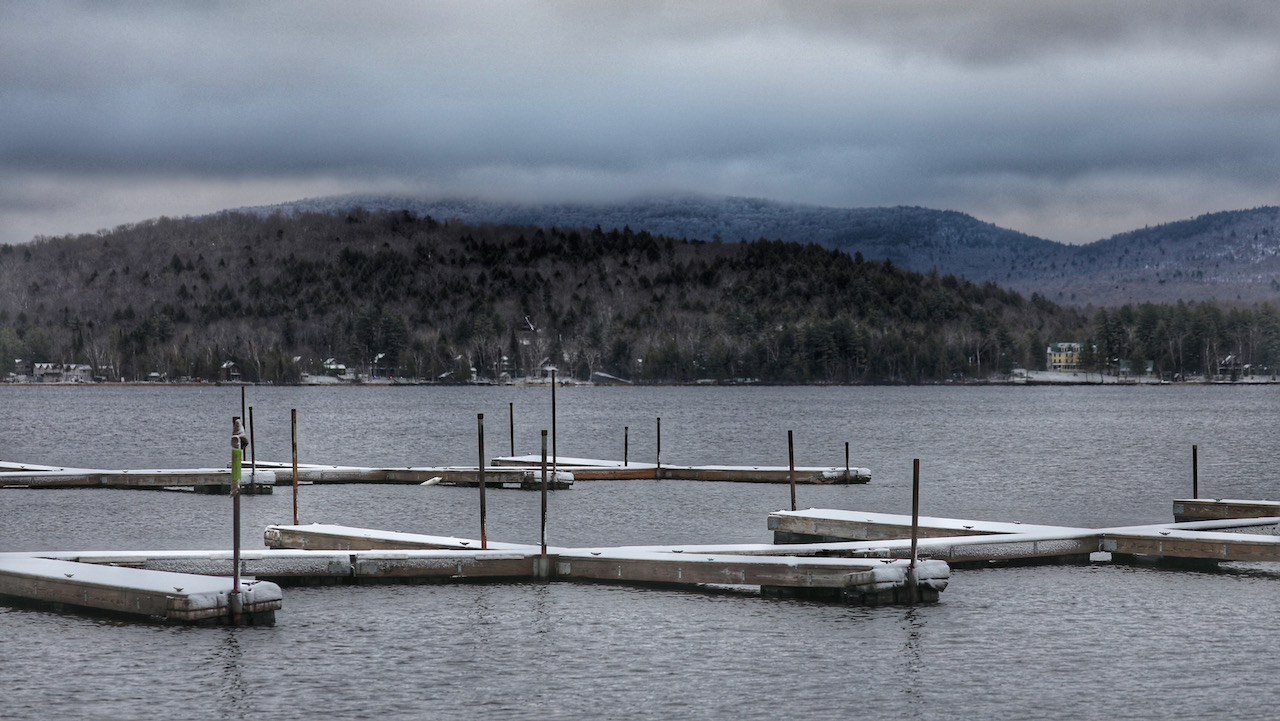 Docks covered in sow, with cloudy mountain in the distance.