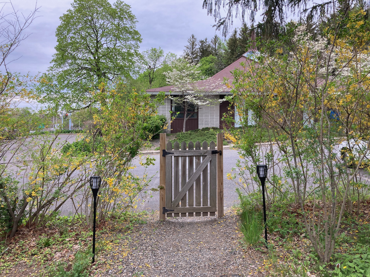 Gate with no fence at end of sidewalk.
