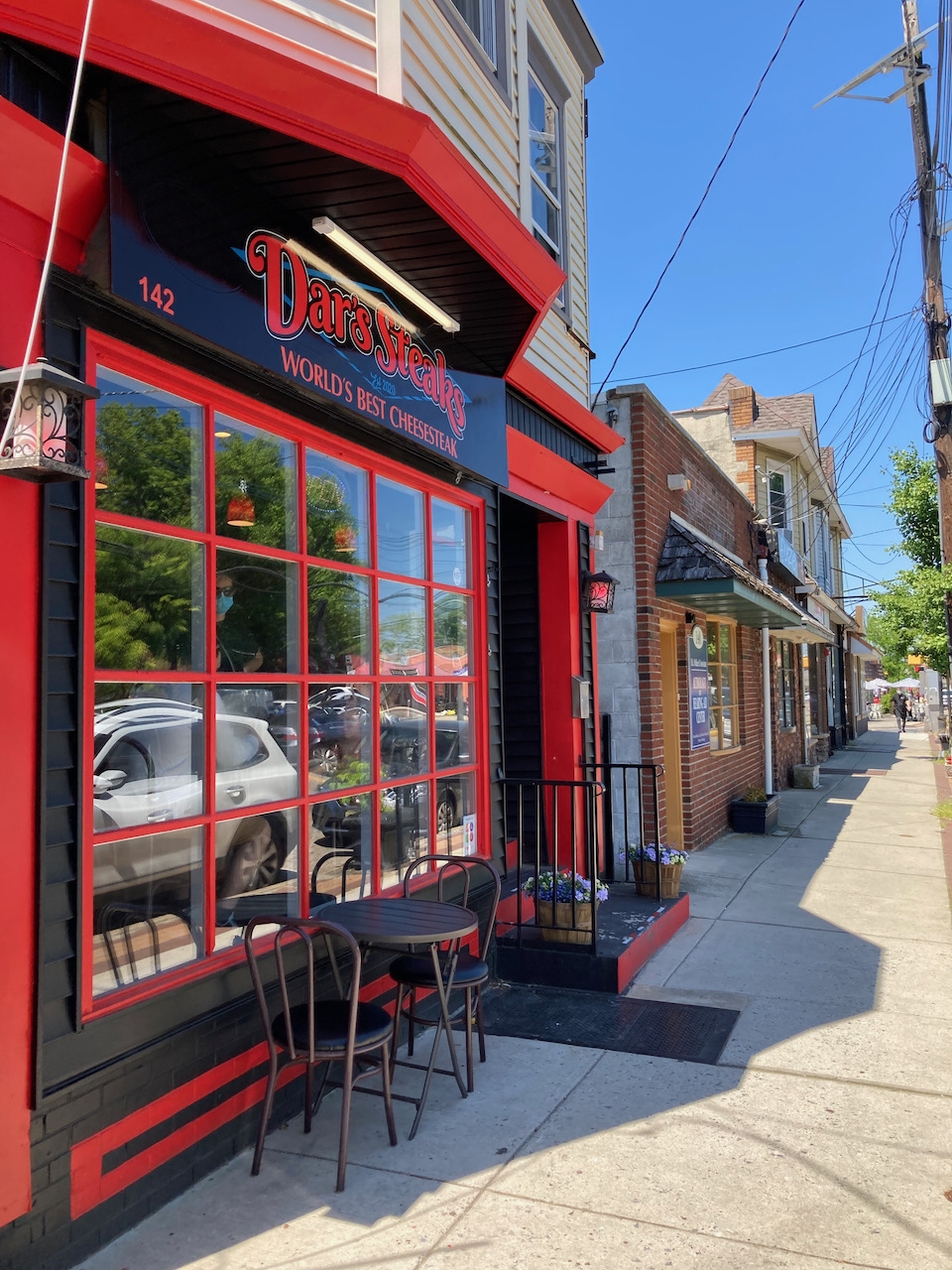 Exterior of Dar's Steaks in row of storefronts.