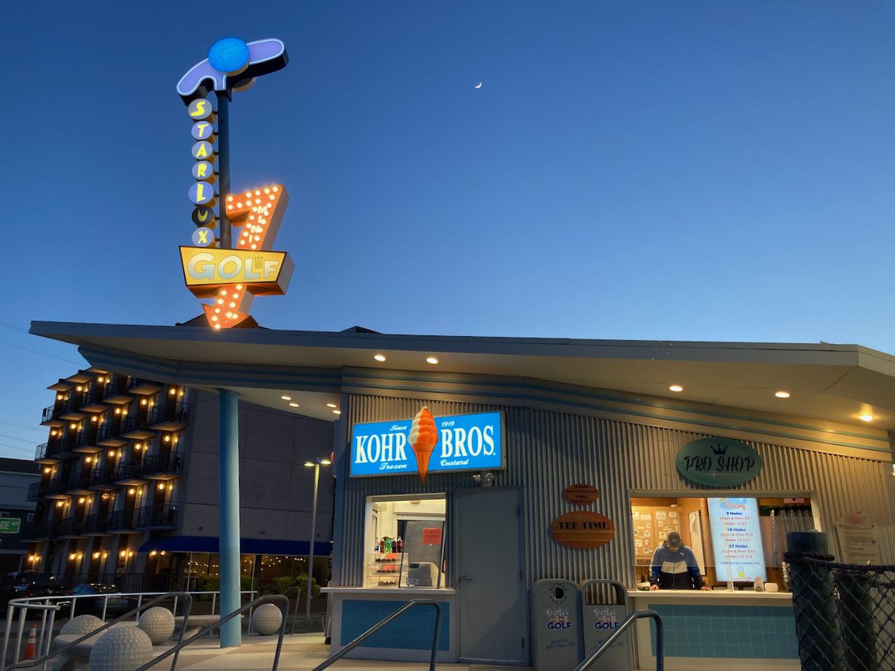 Exterior of Kohr Bros. frozen custard shop, with doo wop style sign for Starlux Golf on top of building.