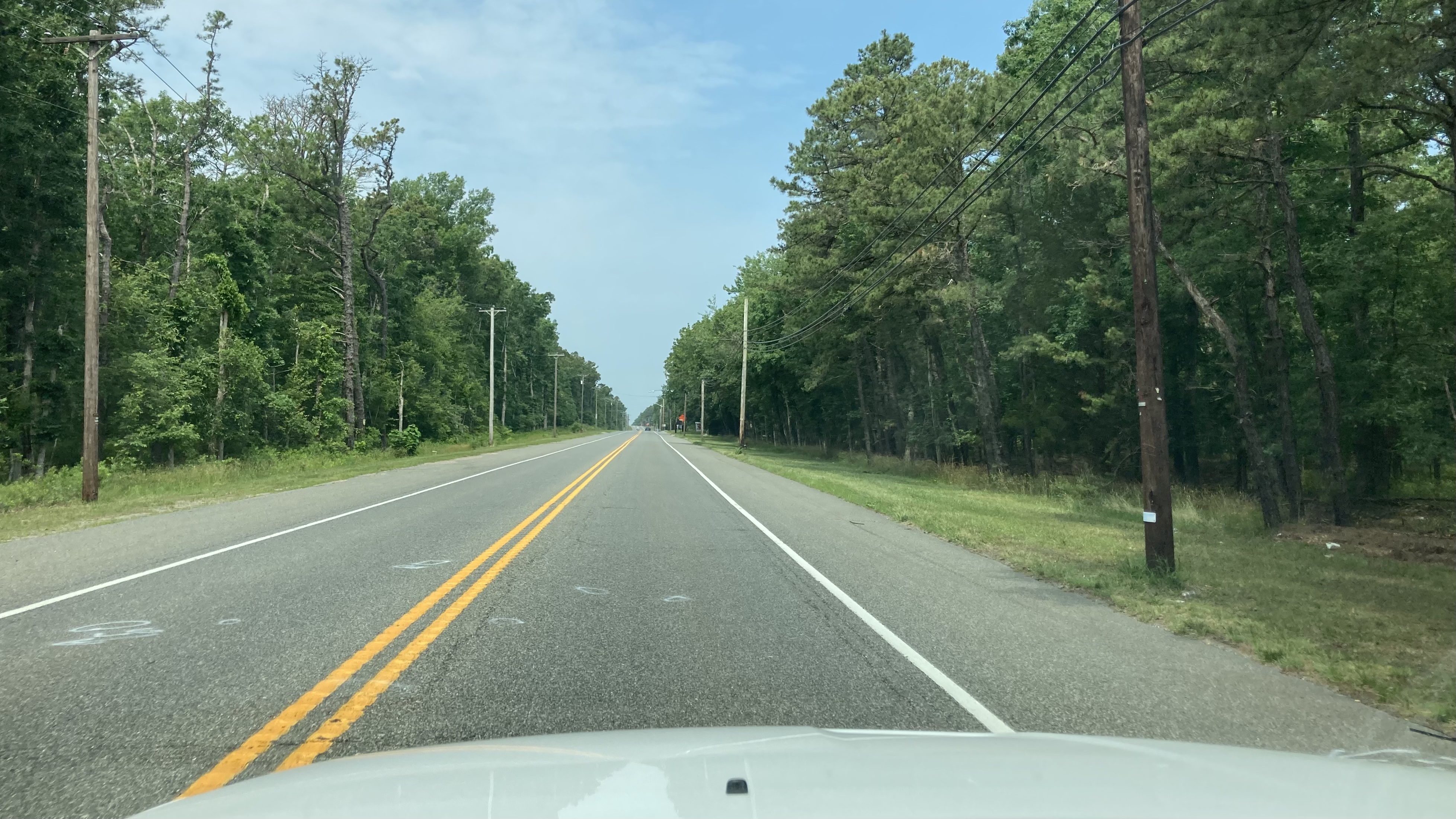 View of Route 50, with white hood of SUV in foreground.