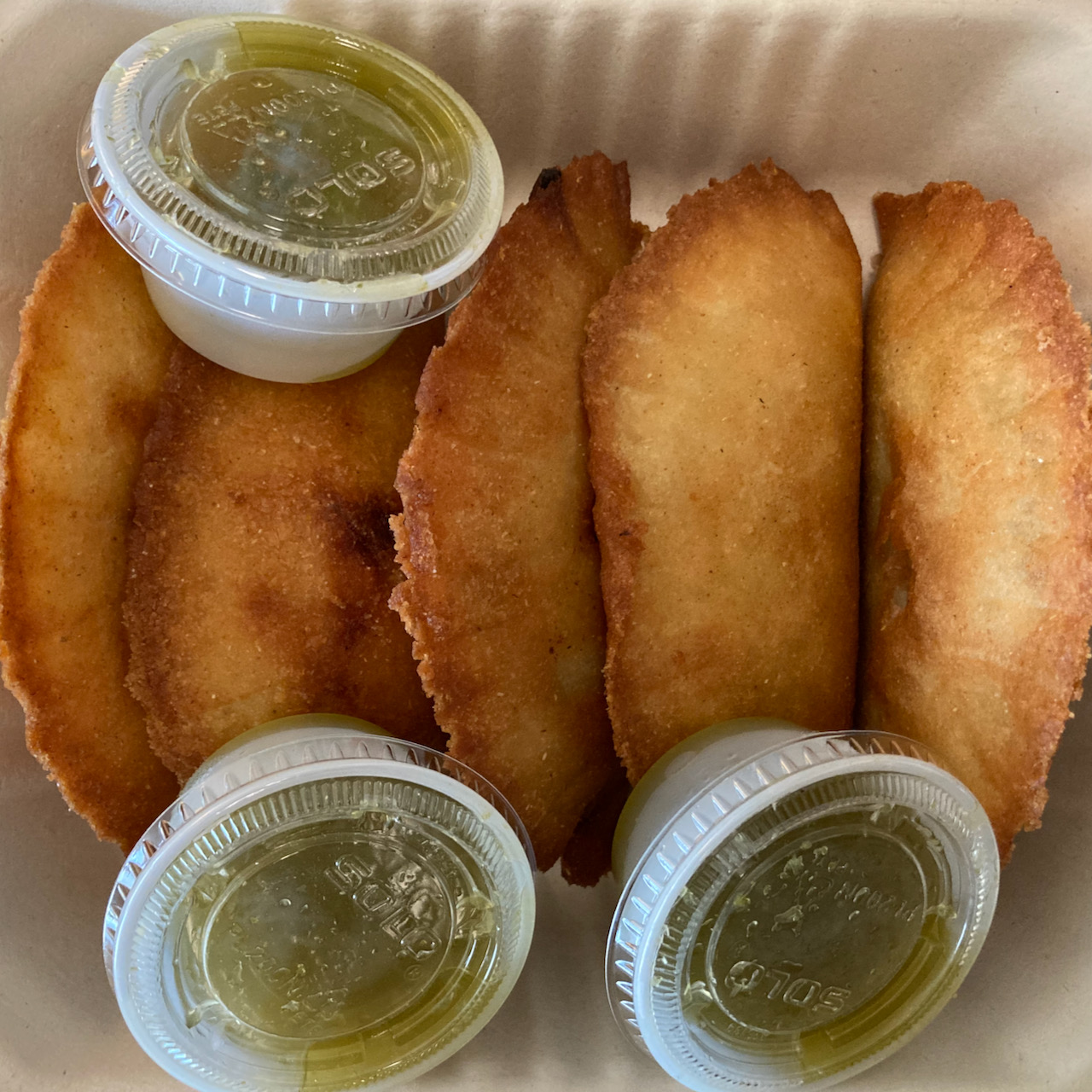 Box with empanadas and sauce.