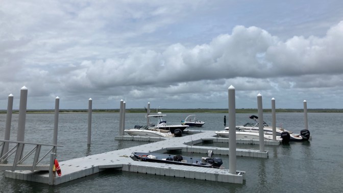 View of bay with dock and boats in foreground.