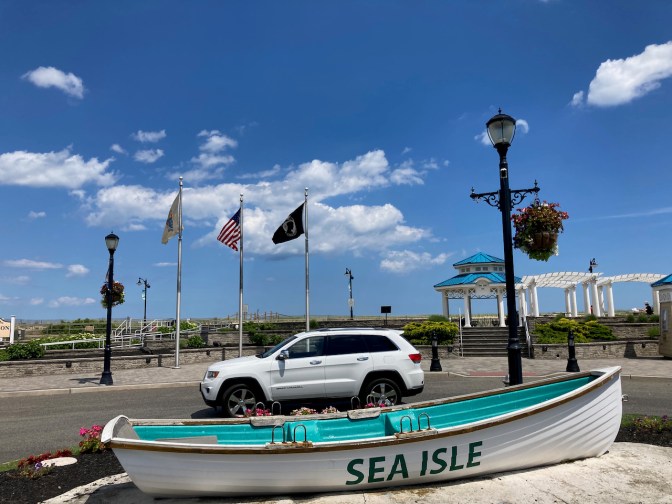 Jeep Grand Cherokee parked in front of row boat that says SEA ISLE on side.