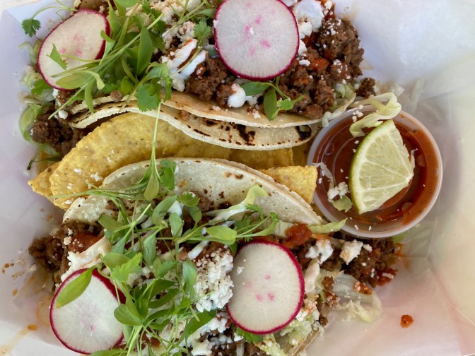 Two tacos in paper box.