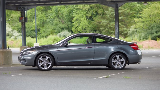 2012 Honda Accord coupe parked beneath covering in parking lot.