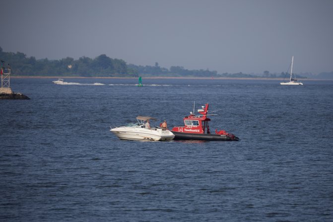 Tow boat coming to assist stricken motor boat.