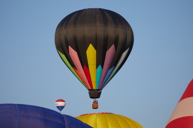 Multicolored balloon above three other balloons.