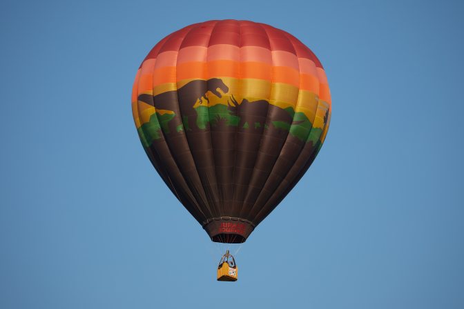 Balloon with scene of Tyrannosaurs Rex fighting Triceratops.
