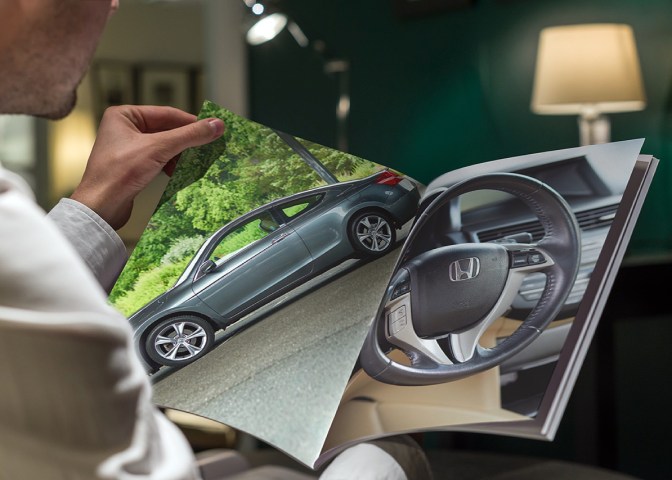 Image of man holding brochure, with photos of 2012 Honda Accord in brochure.
